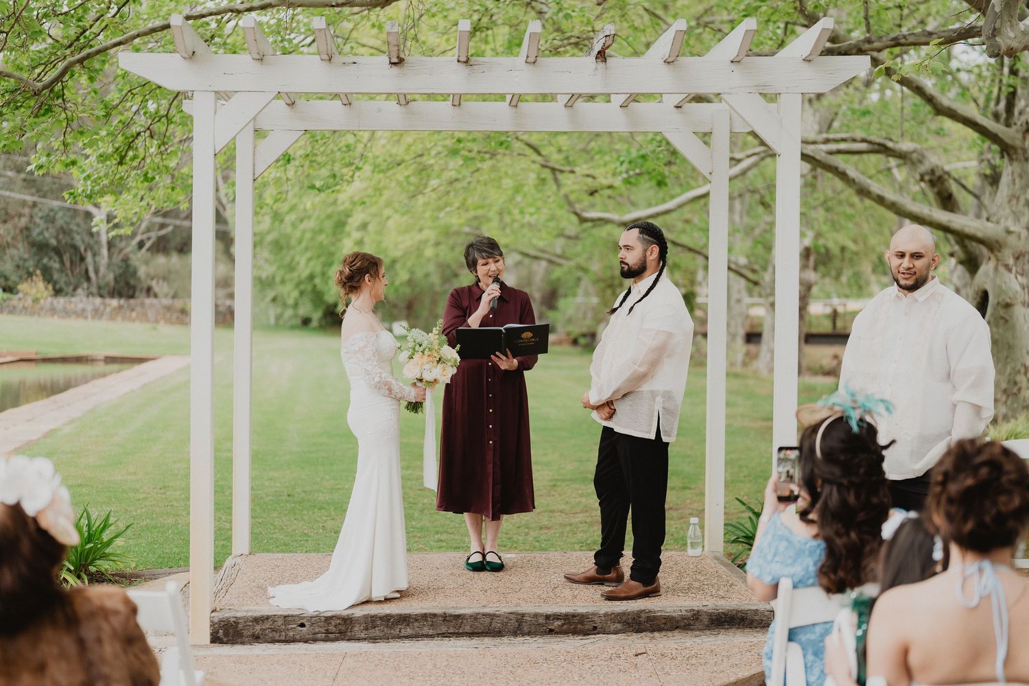 Christopher and Lucy exchanging vows under the garden arch