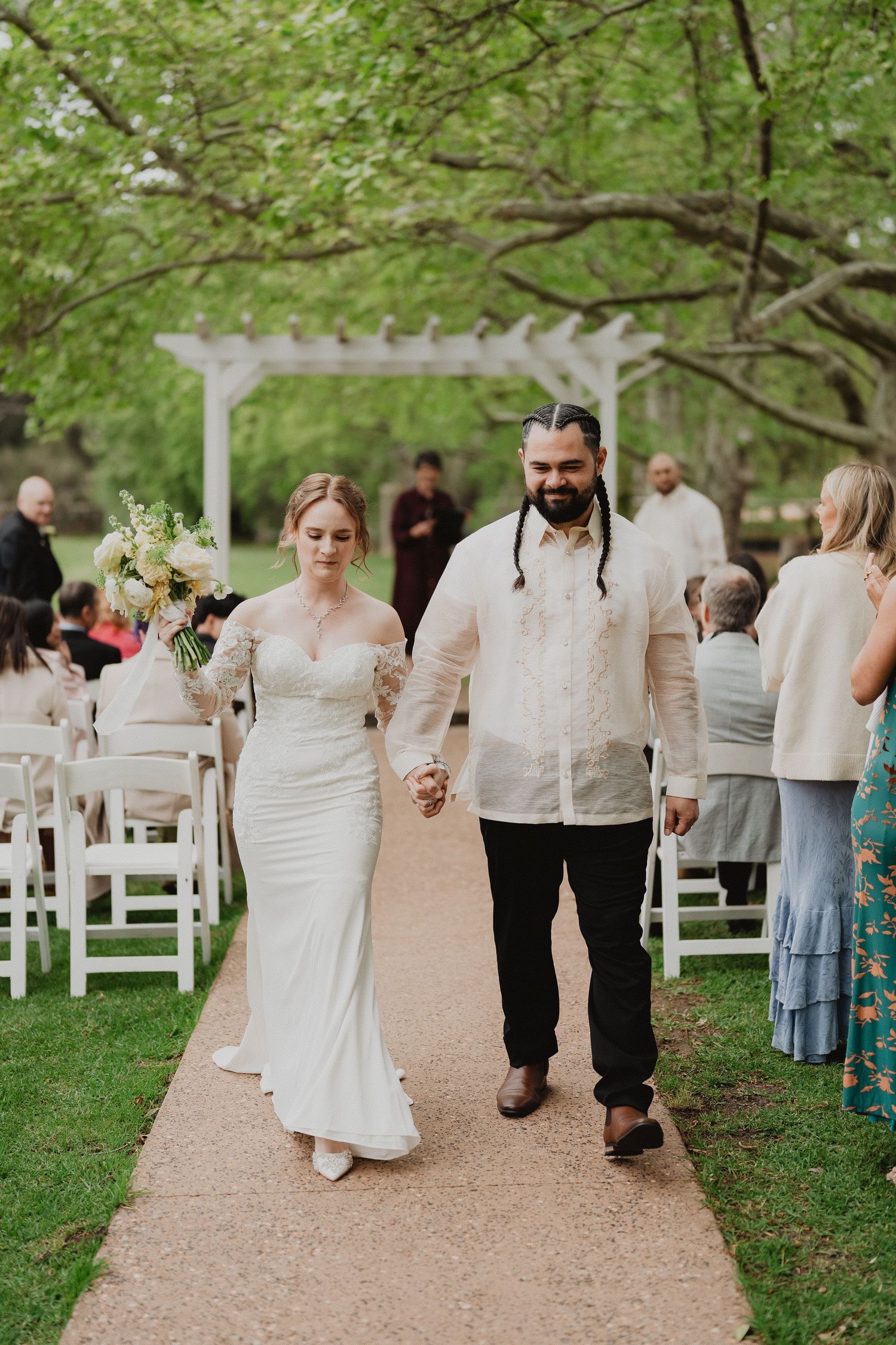Christopher and Lucy walking back up the aisle as newlyweds