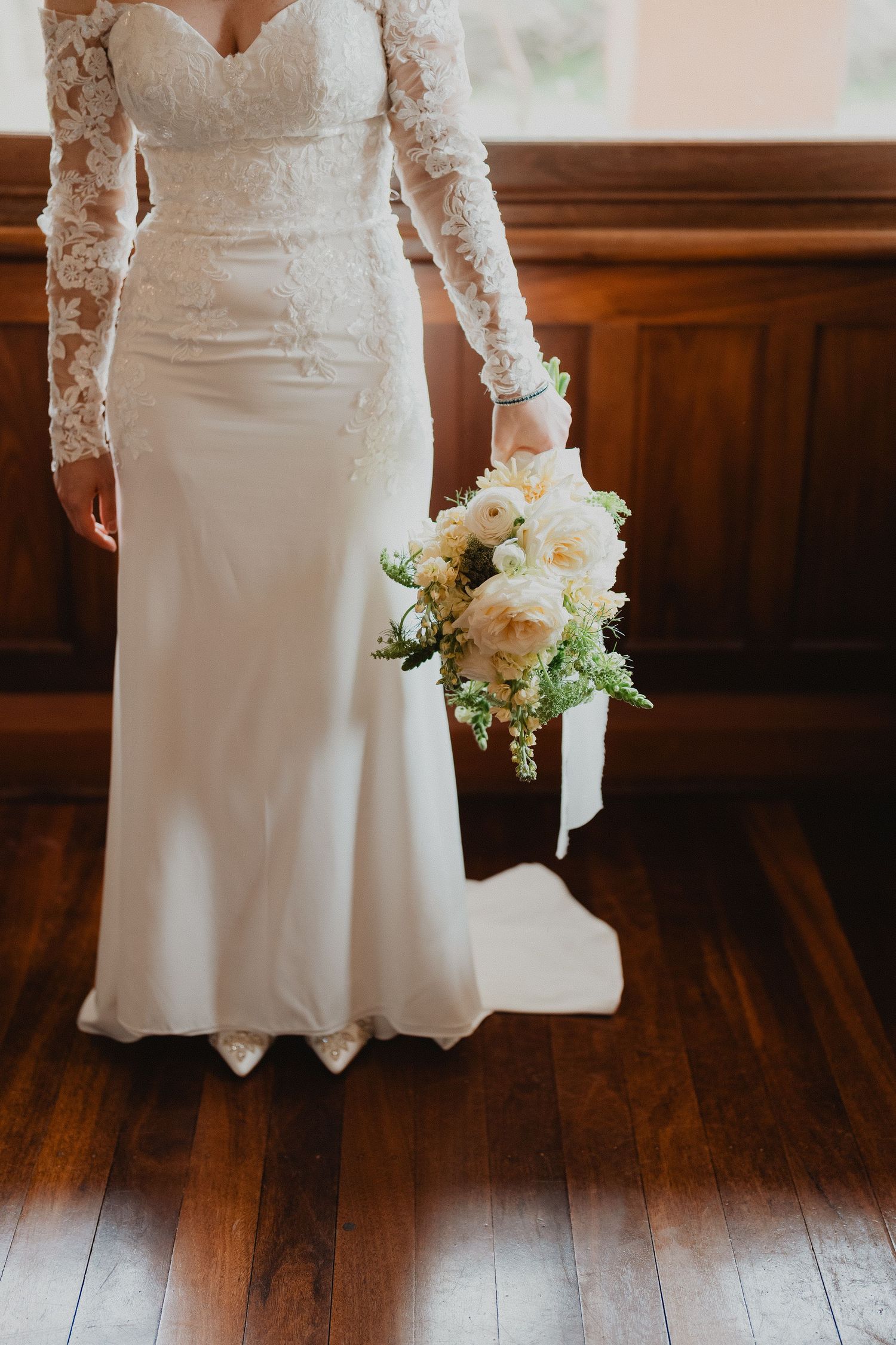 Lucy holding her bouquet in her wedding gown