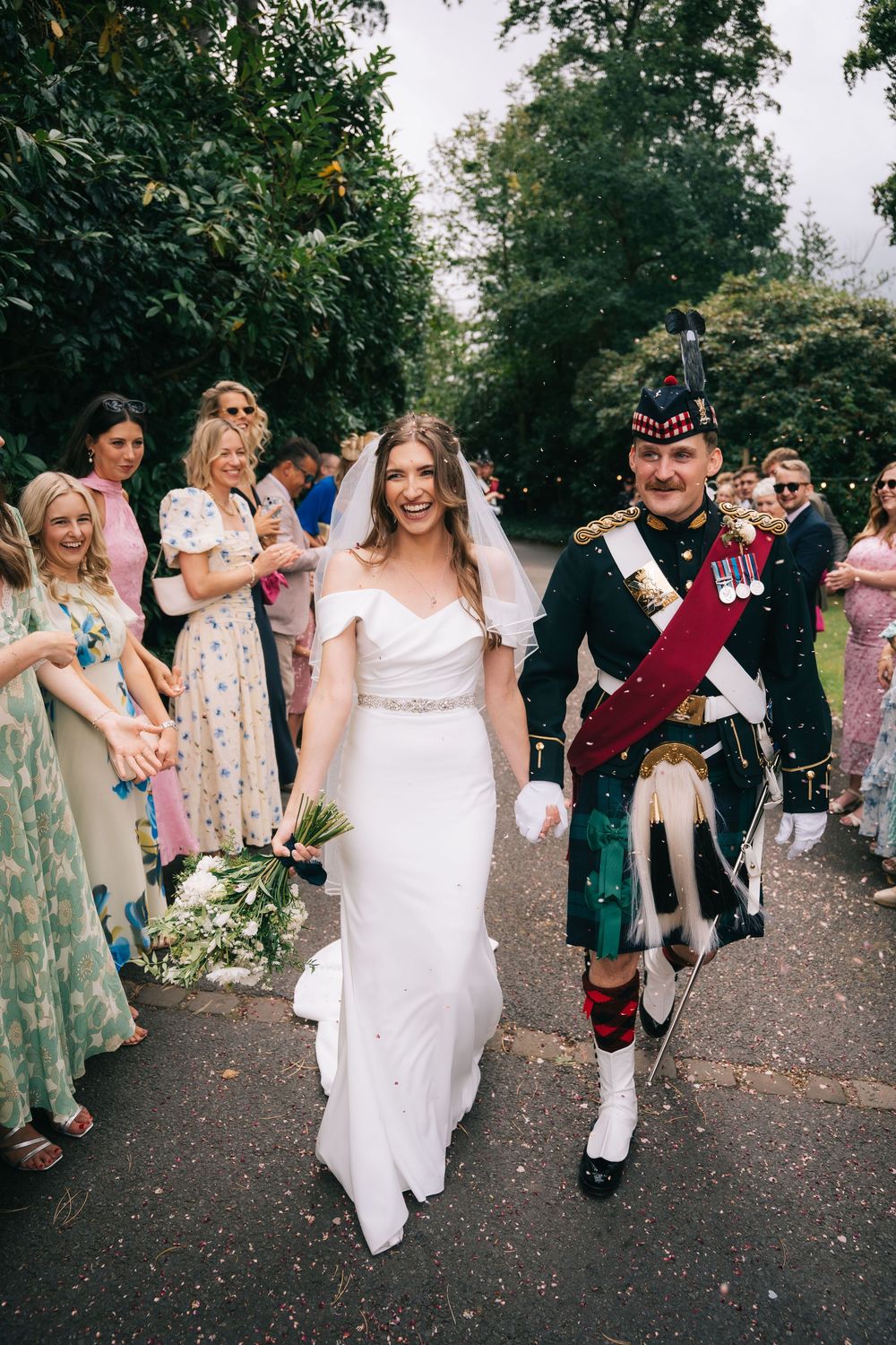Wedding guests celebrate by throwing confetti at a couple during an outdoor garden ceremony celebration, Pendrell Hall, Wolverhampton