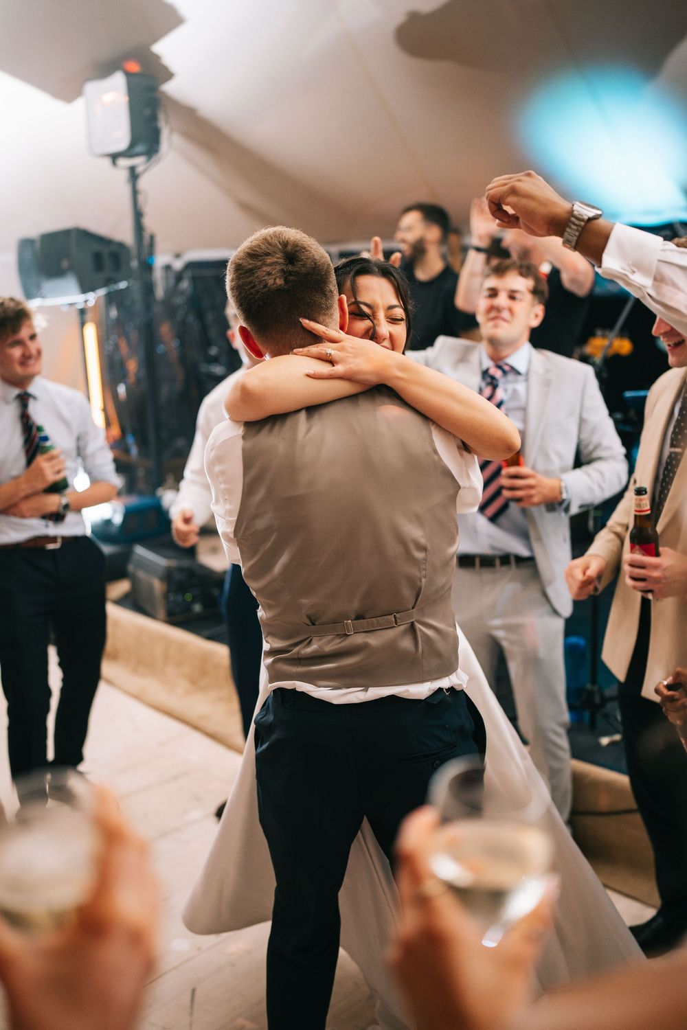 Couples dancing together at a wedding reception with guests watching in the background.
