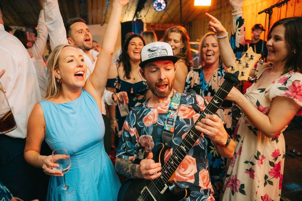 A lively crowd of wedding guests dancing and celebrating together on a dance floor at a reception party, Bromwich Park Farm, Shropshire