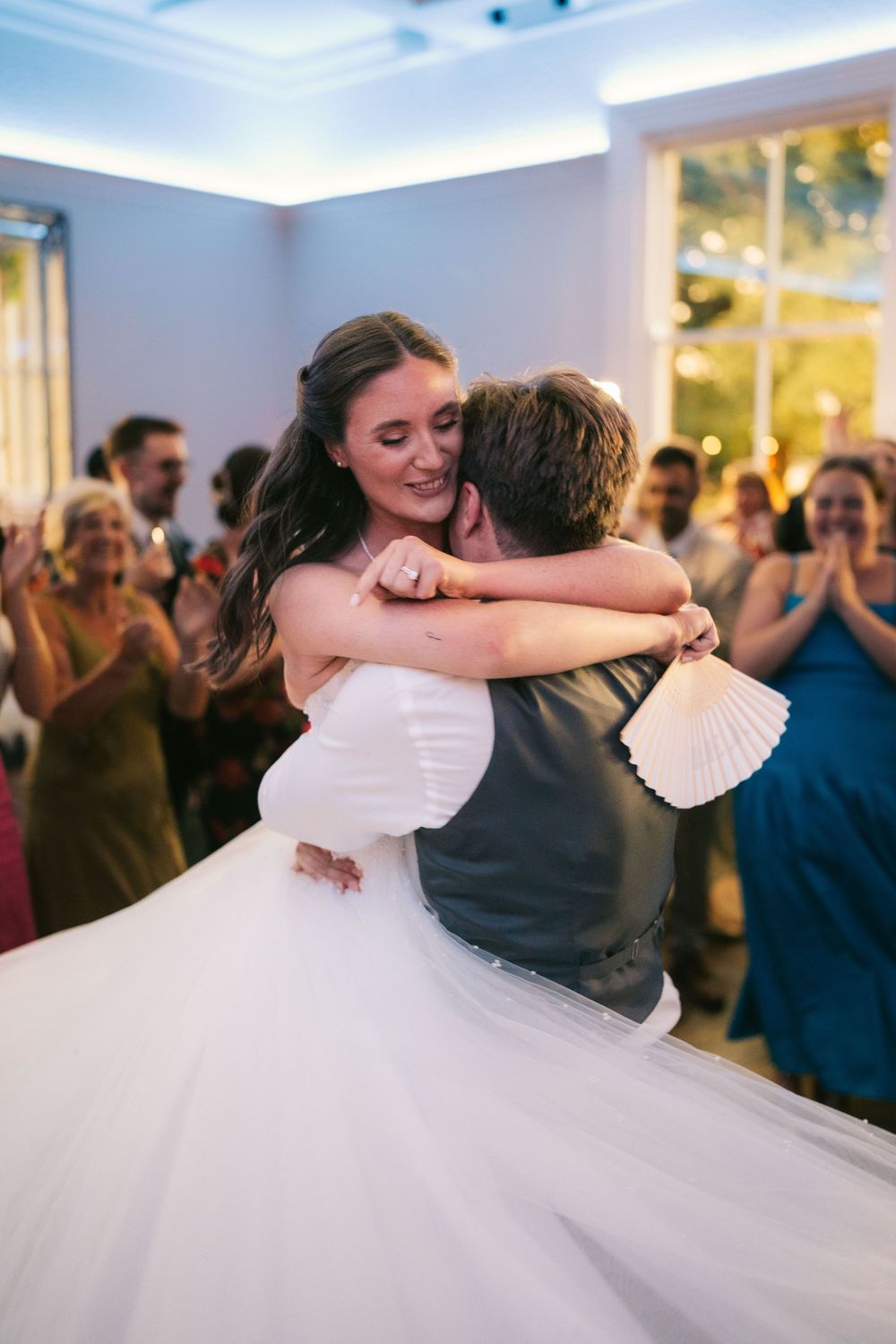A couple shares a romantic dance at their wedding reception as guests look on from the background, Pendrell Hall, Wolverhampton