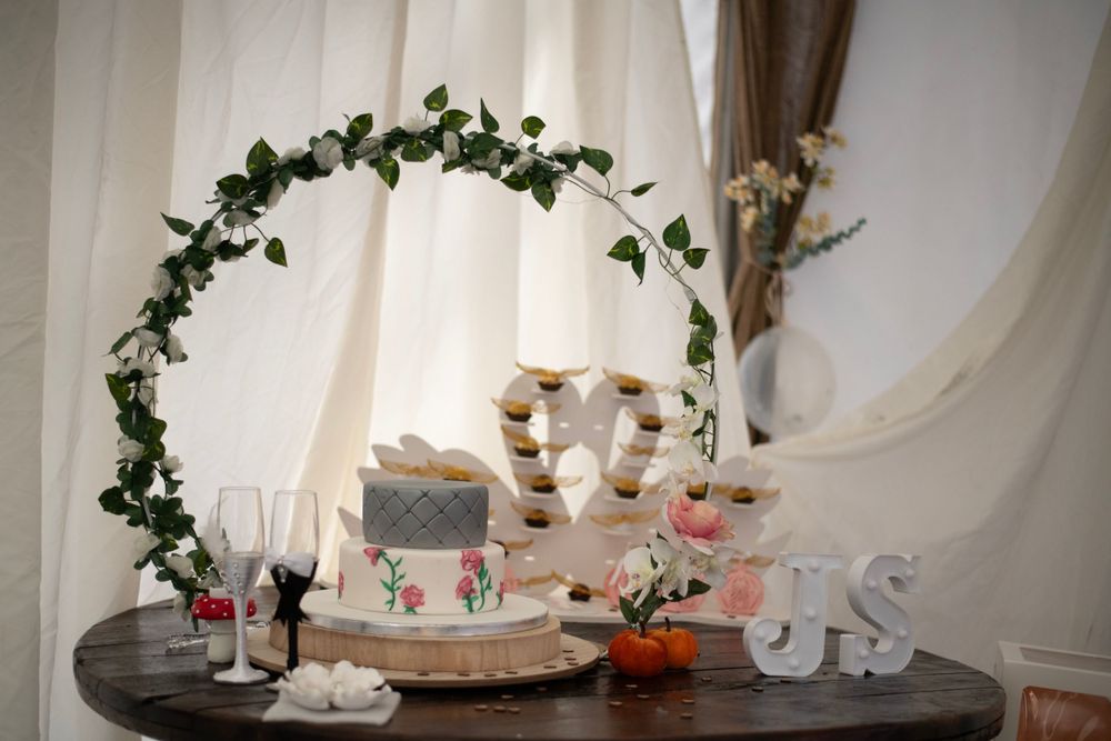 Wedding dessert table with floral arch decoration and Mr & Mrs sign.