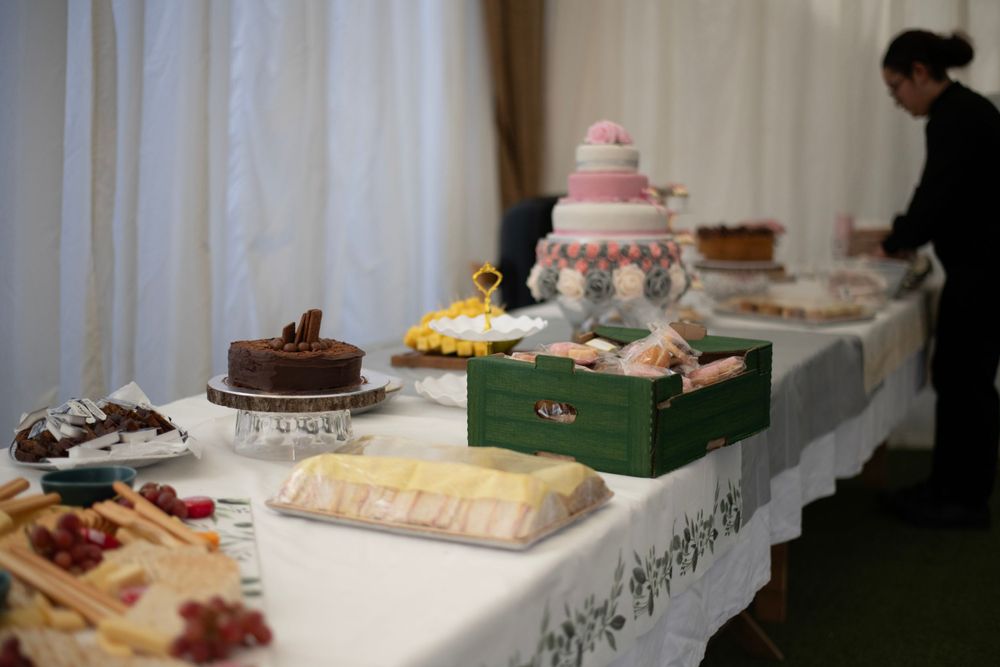 Wedding dessert buffet table with various cakes and treats displayed.
