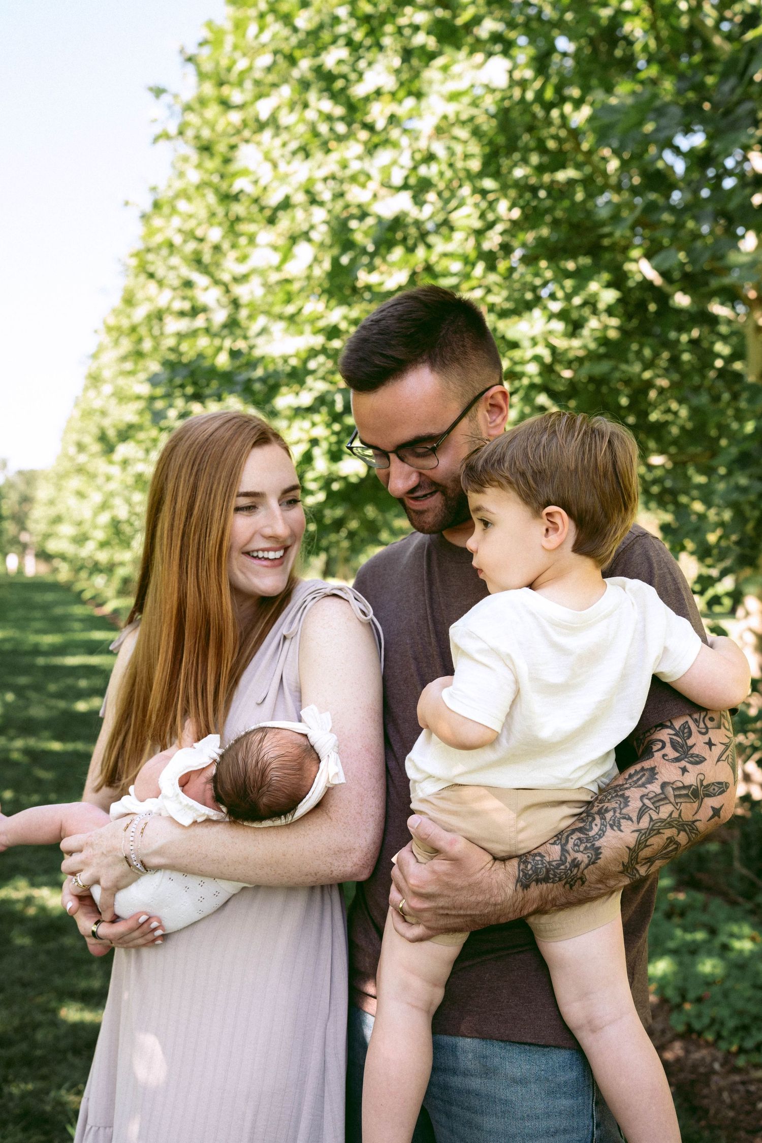 An engagement photo session at Hidden Valley Orchard in Lebanon Ohio with a couple posing near a tree looking at each other smiling.