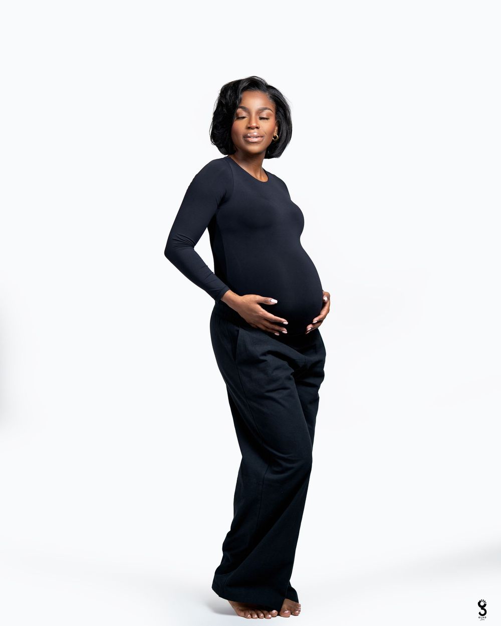 Elegant maternity portrait series showing a pregnant woman in a black dress against a white backdrop.