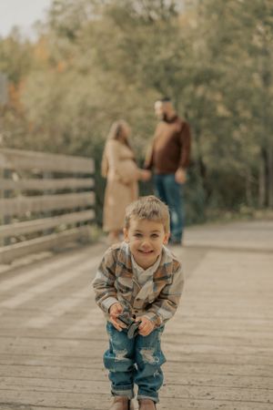 A playful moment captured on a wooden bridge during an autumn photo session.