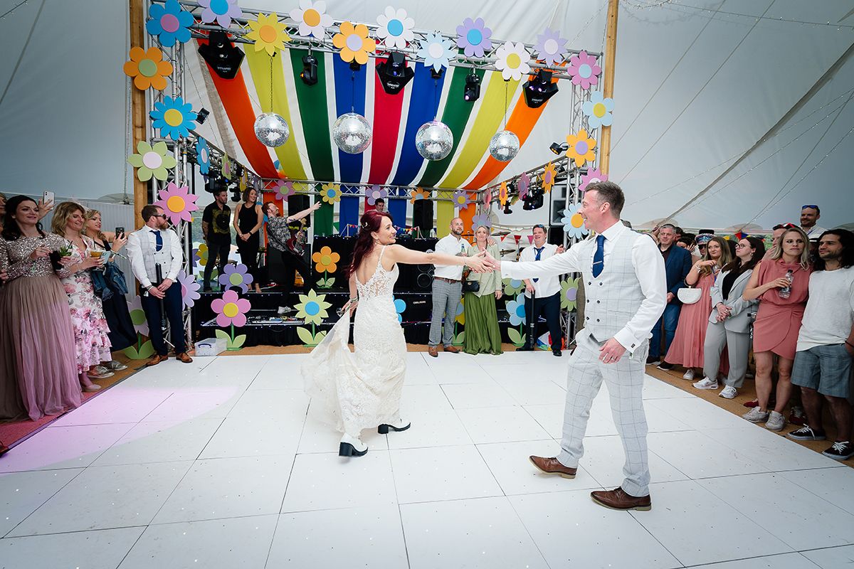 Wedding reception dance floor decorated with colorful streamers and festive lighting.