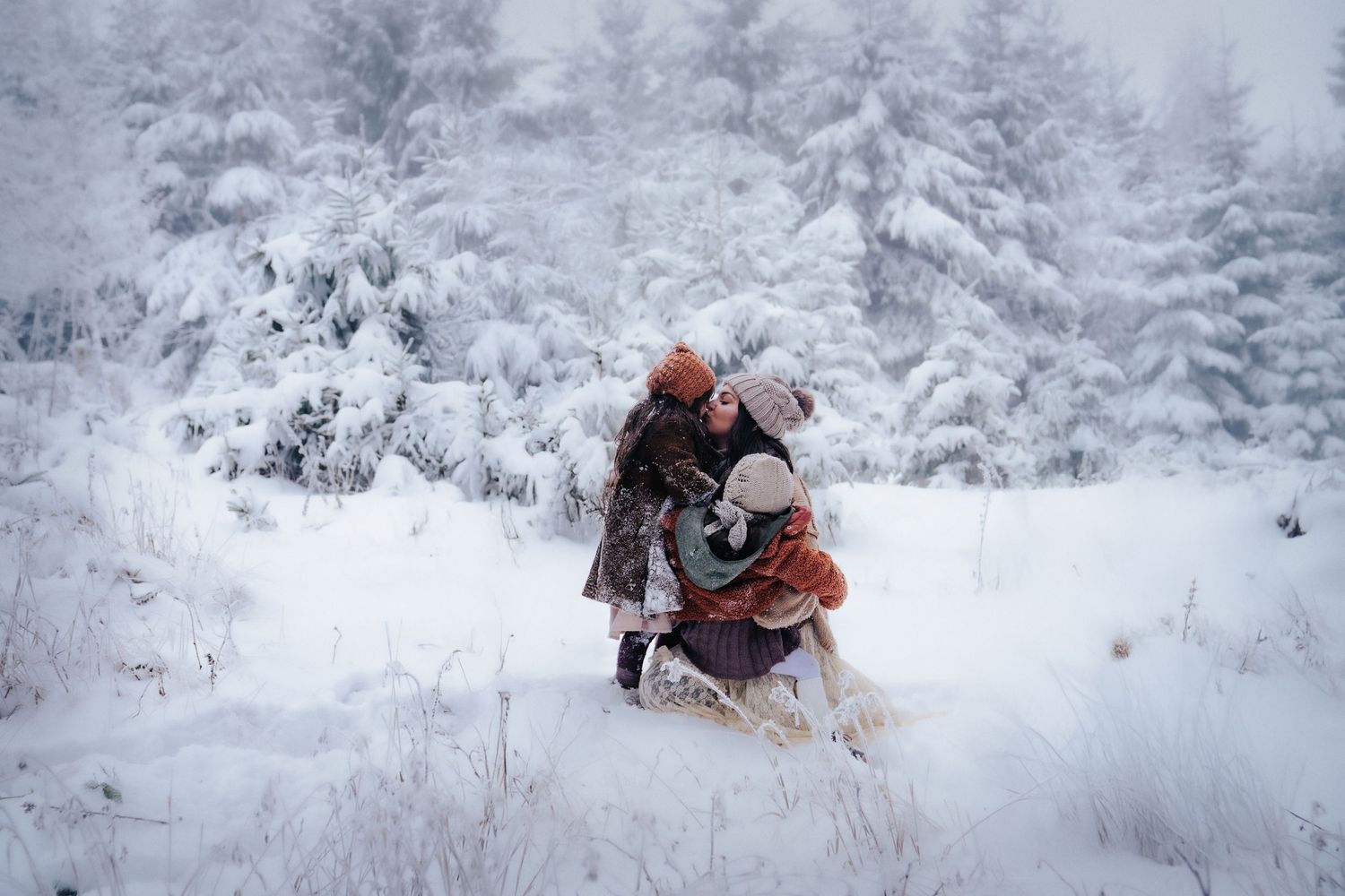 A person in winter clothing sits on an orange sled in a snowy forest landscape during a snowfall.