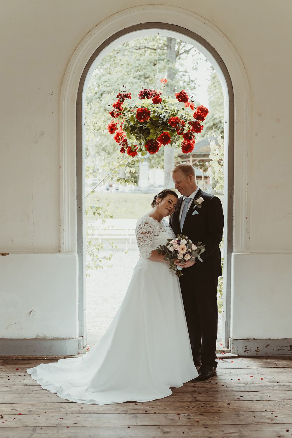 Bröllopsfotografering av brudporträtt, brudparet står i ett vackert vit valv till Högbrunnen, Medevi Brunn. Bröllopsfoto Josefin Landhagen