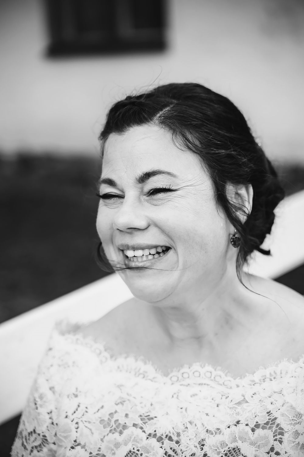 Bröllop, ögonblicksbild av bruden som ler stor och skrattar. Ett levande porträtt av bröllopsfotograf i Östergötland, Josefin Landhagen.