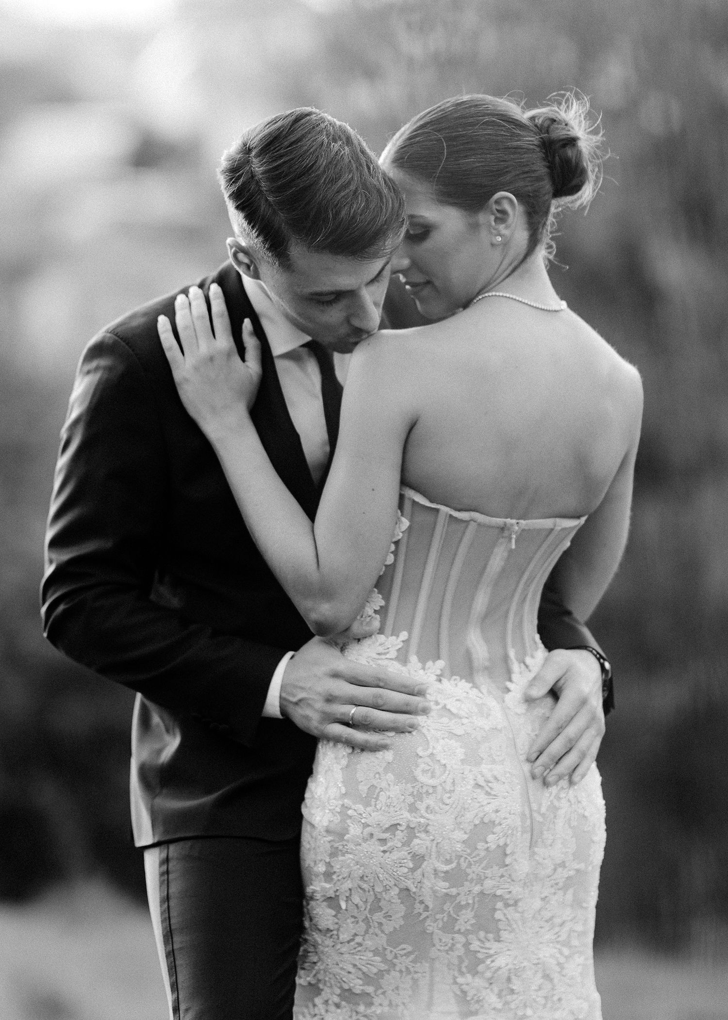 Black and white wedding photo series showing romantic moments between newlyweds in formal attire.
