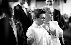 A black and white photo montage showing candid moments from a wedding celebration with guests and dancing.