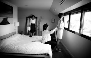 A series of black and white interior photographs showing minimalist hotel rooms with beds and windows.