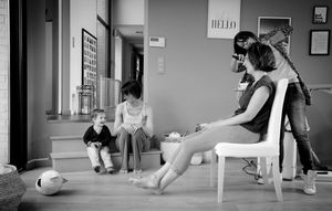 A sequence of black and white photos showing a person practicing yoga poses on a mat in a studio.