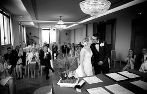 A black and white panoramic collage showing multiple wedding ceremony and reception scenes with a chandelier.