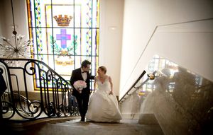 Interior venue with stained glass windows and ornate decorative details for a wedding ceremony.
