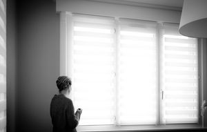 Black and white panoramic view of a modern interior room with windows and furniture silhouettes.