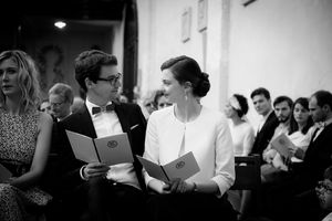 Black and white photos of a choir group practicing and singing together in a rehearsal space.