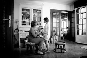 A series of black and white photographs showing people reading in various indoor settings with bookshelves and windows.