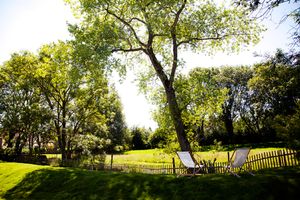 Scenic panoramic view of a lush green golf course with mature trees and rolling hills in the background.