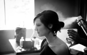 Black and white profile silhouette in soft window light with elegant hair styling.