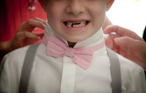 A close-up series of images showing a pink bow tie and white dress shirt collar.