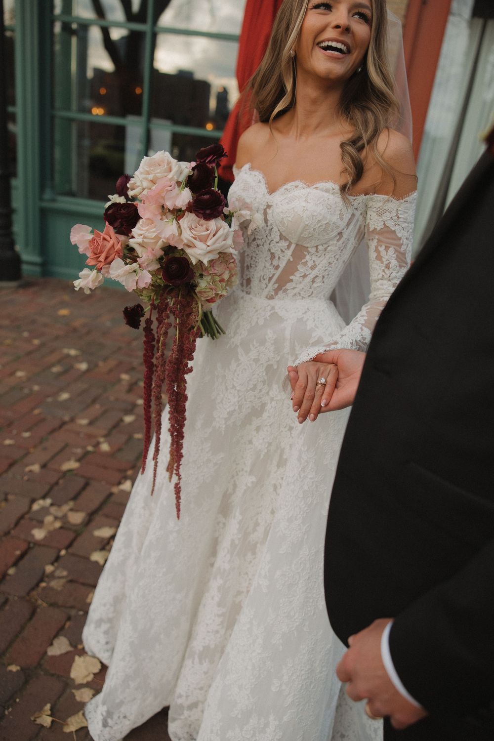 A close-up view of a delicate lace wedding dress with long sleeves and floral details.