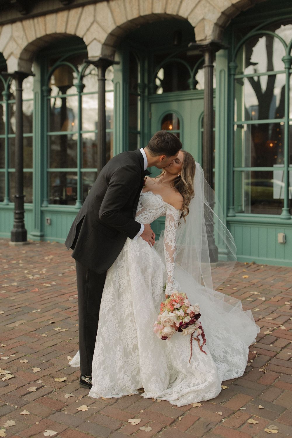 A romantic wedding couple shares intimate moments in a series of photos under an ornate arched colonnade.