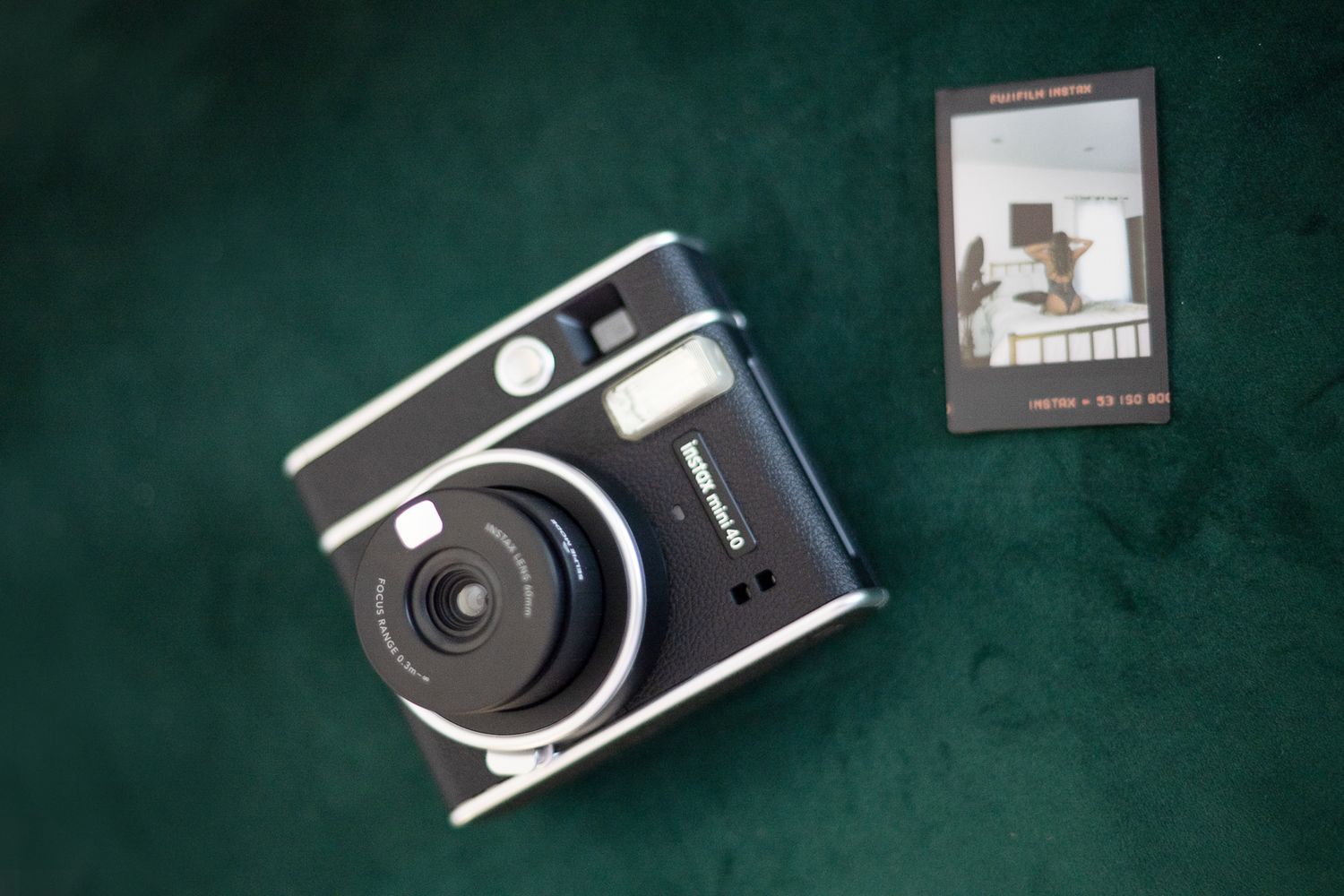 A collection of vintage film cameras arranged in a row on a dark green textured surface.