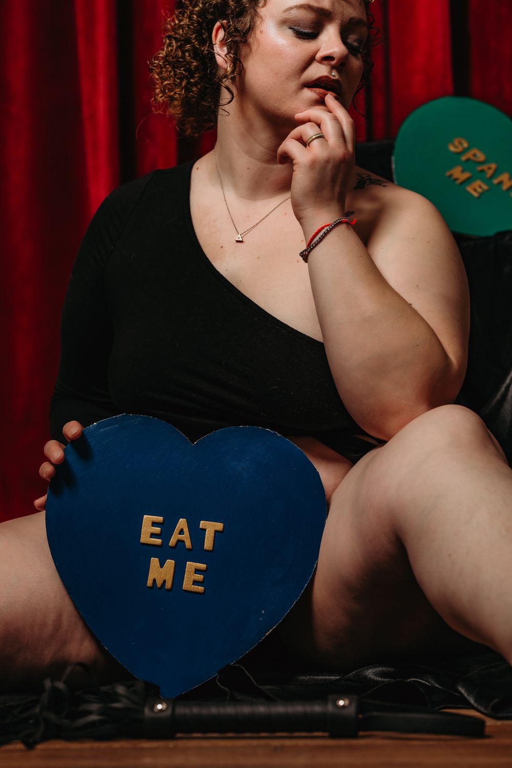A series of heart-shaped signs with text against a red curtain backdrop creates a romantic atmosphere.
