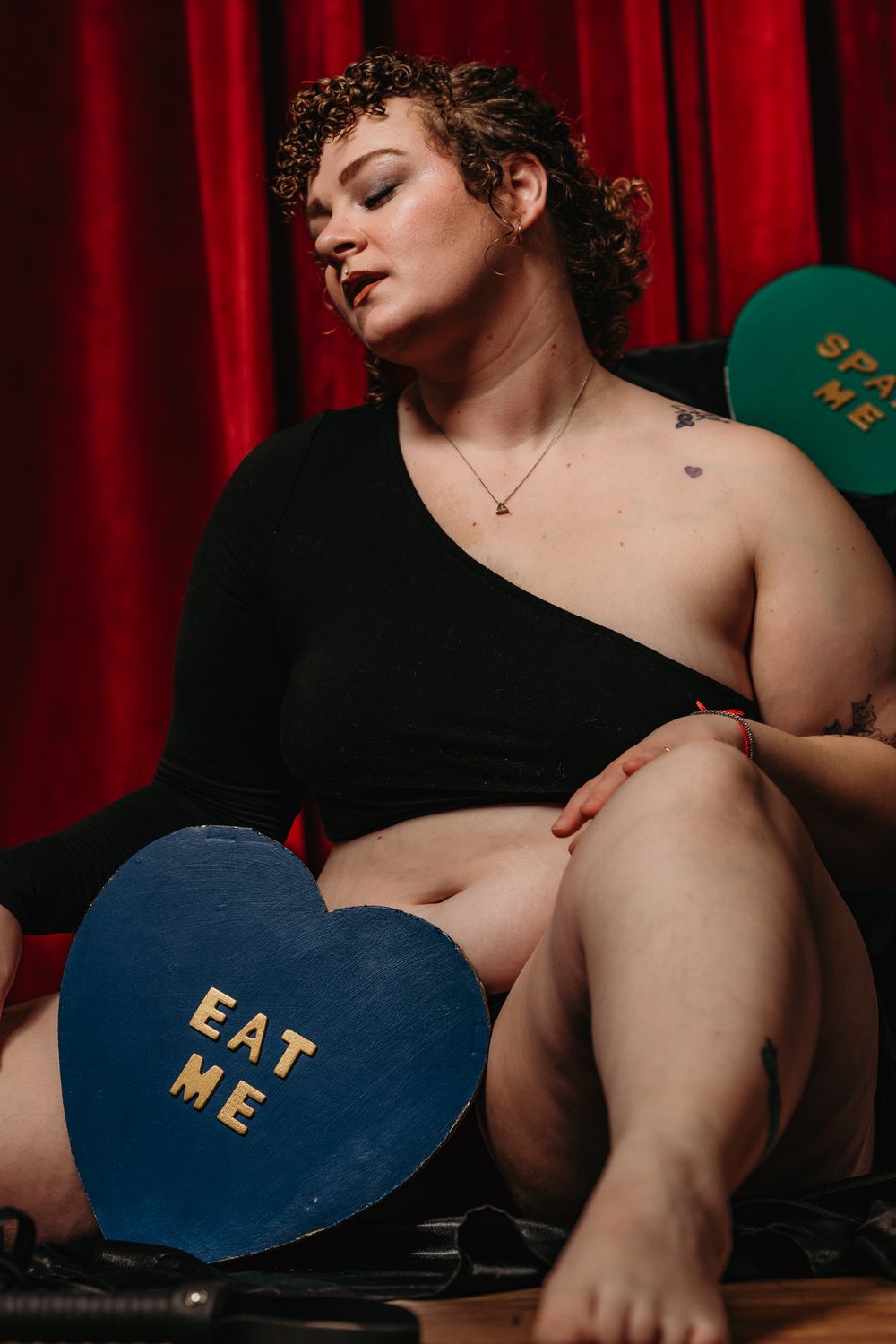 A series of photos shows a heart-shaped object with text against a dark background with red curtains.