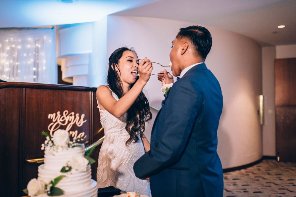 Newlyweds sharing a sweet moment during their wedding cake cutting ceremony.