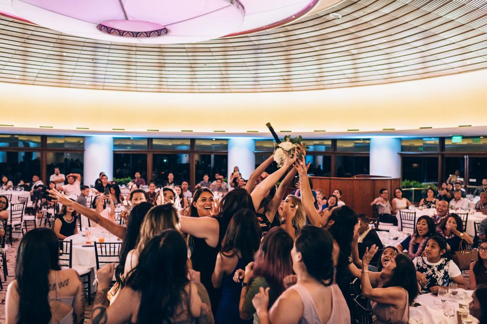 Wedding reception venue with elegant curved ceiling architecture and standing guests.