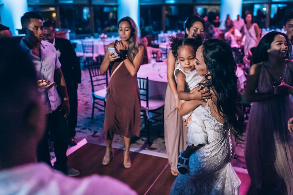 Wedding reception dance floor filled with guests enjoying themselves under ambient lighting.