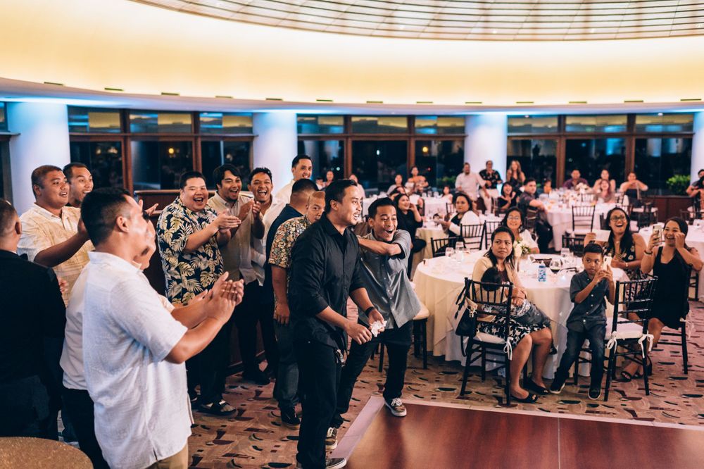 Large banquet hall with curved ceiling details and guests seated at round tables.