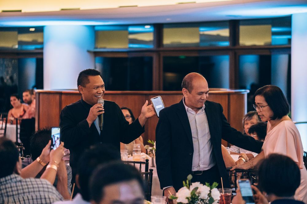 Guests interacting during a wedding reception in a modern venue with ambient lighting.
