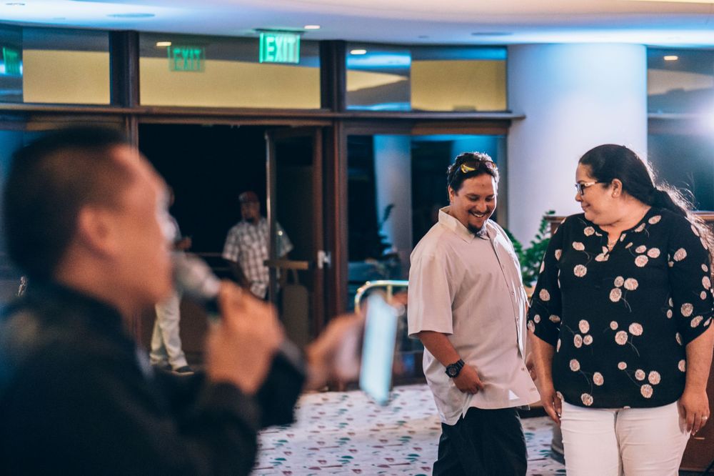 Wedding guests mingling and socializing during an indoor evening reception.