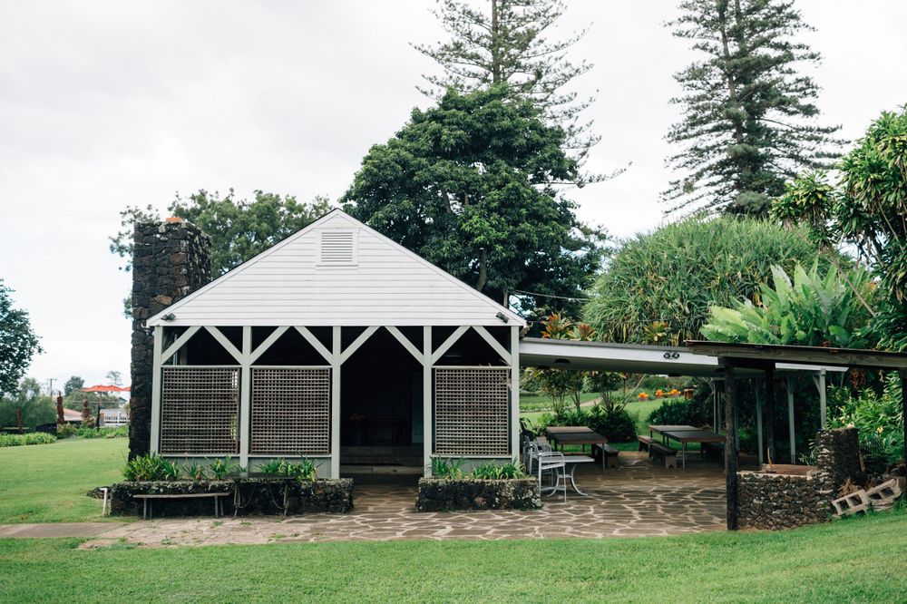 Series of white covered pavilions and structures spread across a landscaped ranch property.