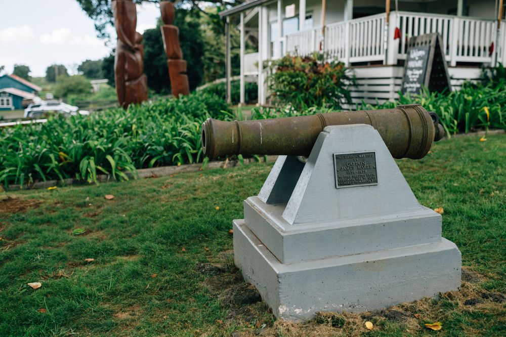 Row of concrete grave markers or memorials on a grassy hillside.