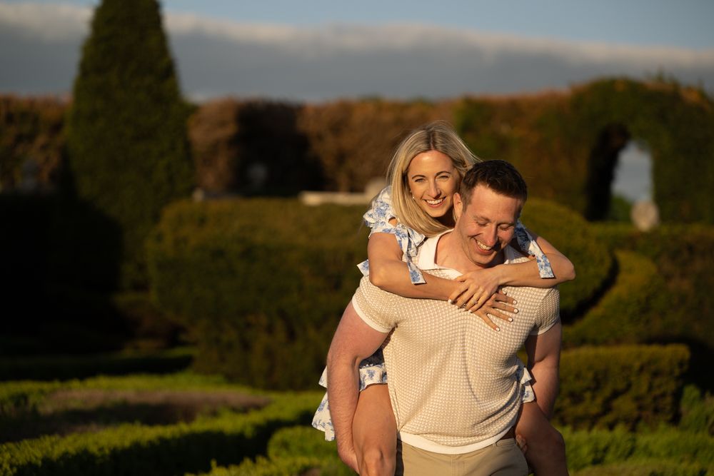 A couple shares a tender moment together in a scenic autumn landscape.