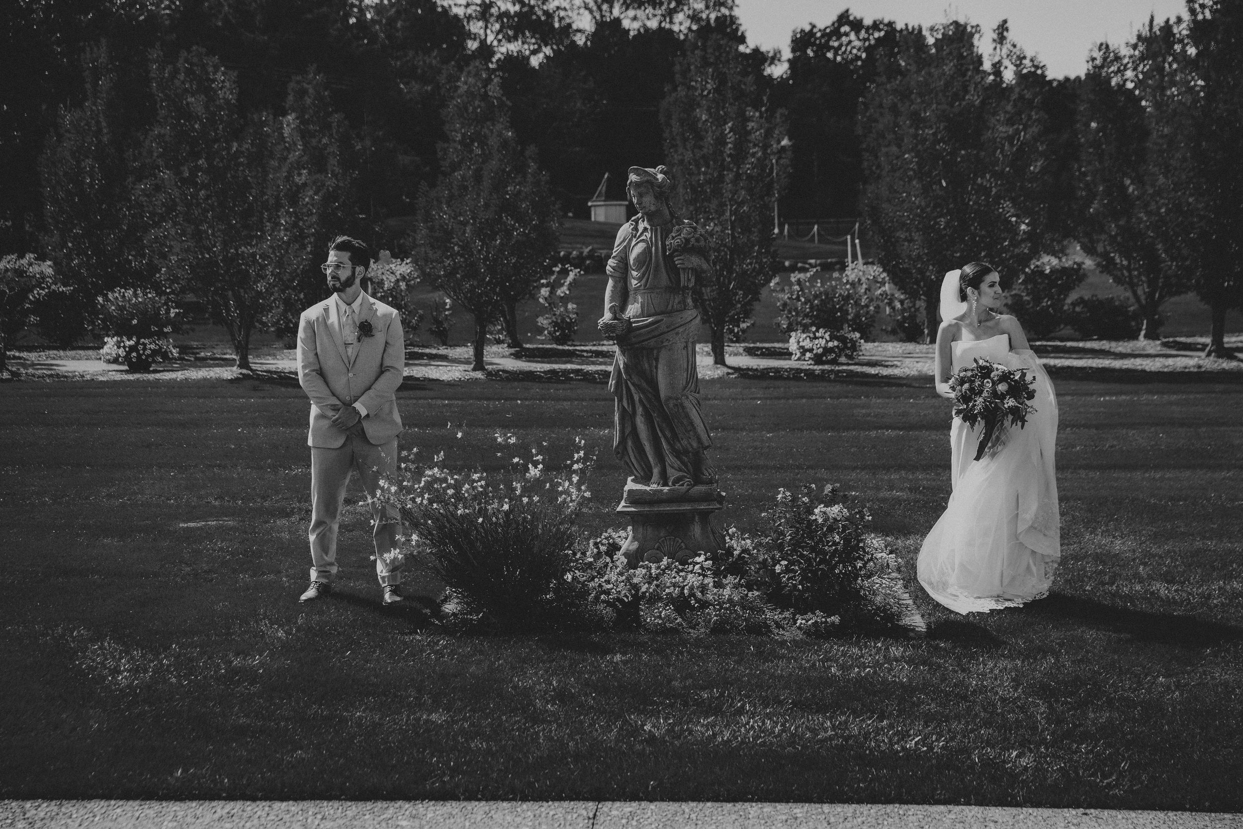 Black and white wedding photography in a serene garden setting.
