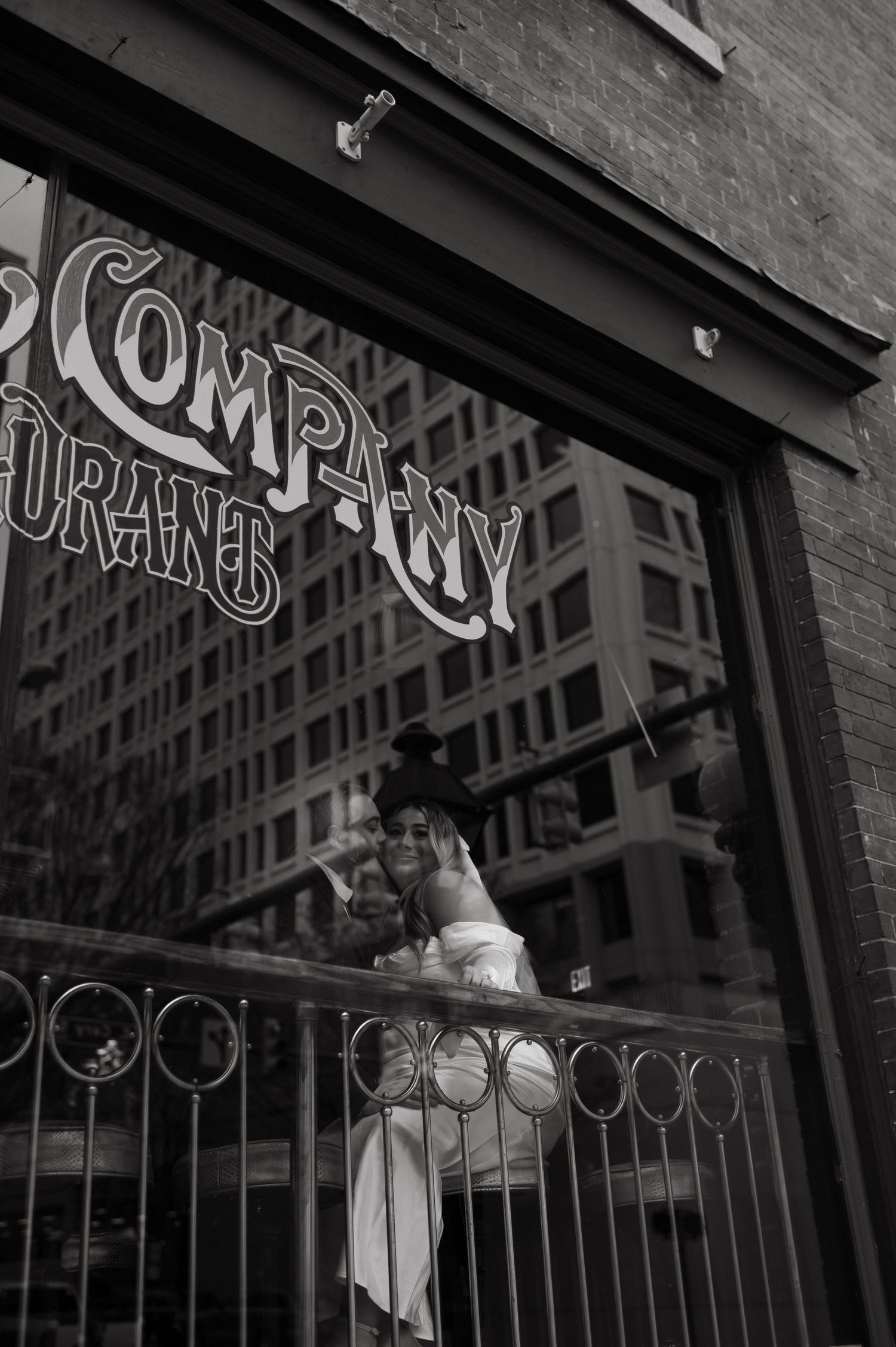 Black and white storefront with ornate vintage signage and decorative railings.