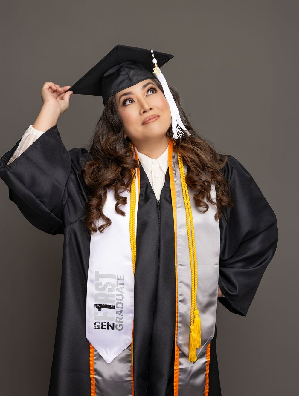 Graduate wearing black academic regalia and gold stole poses with arms raised in celebratory series of photos.