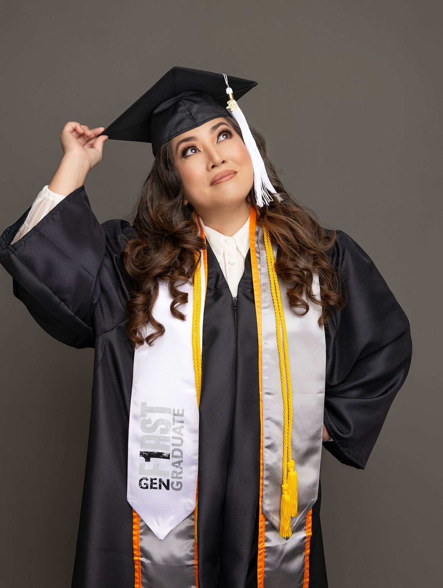 Graduate wearing black academic regalia and gold stole poses with arms raised in celebratory series of photos.