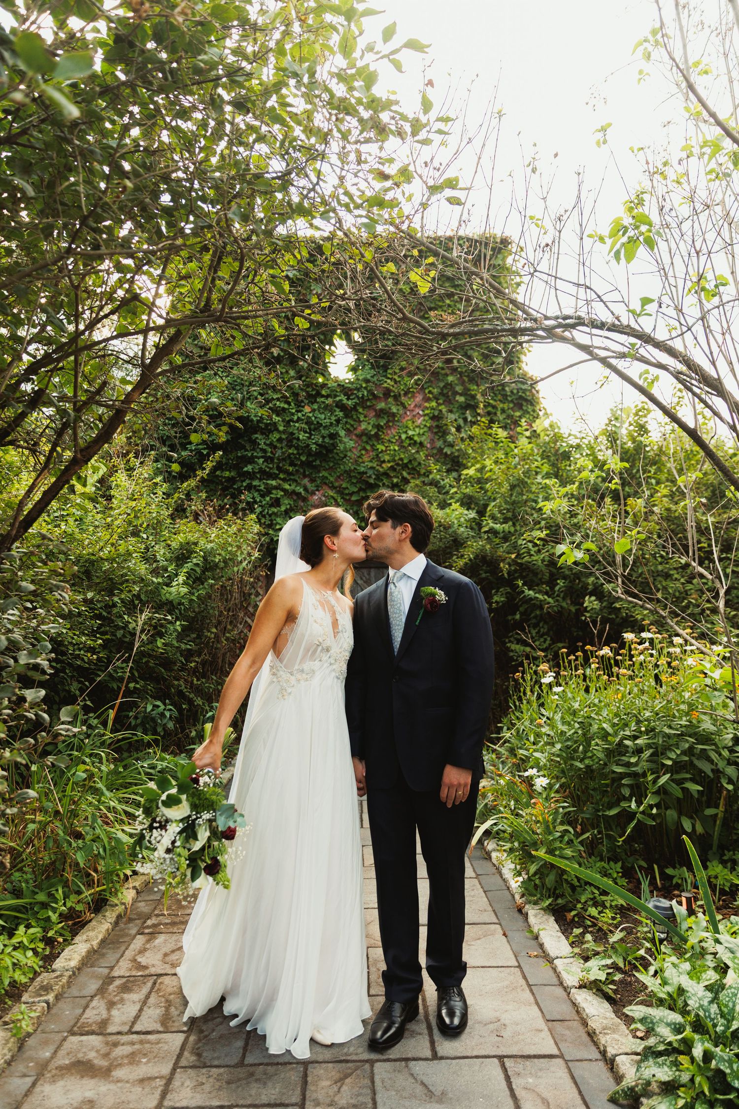 A romantic wedding photo sequence showing a couple walking along a garden path surrounded by lush greenery.