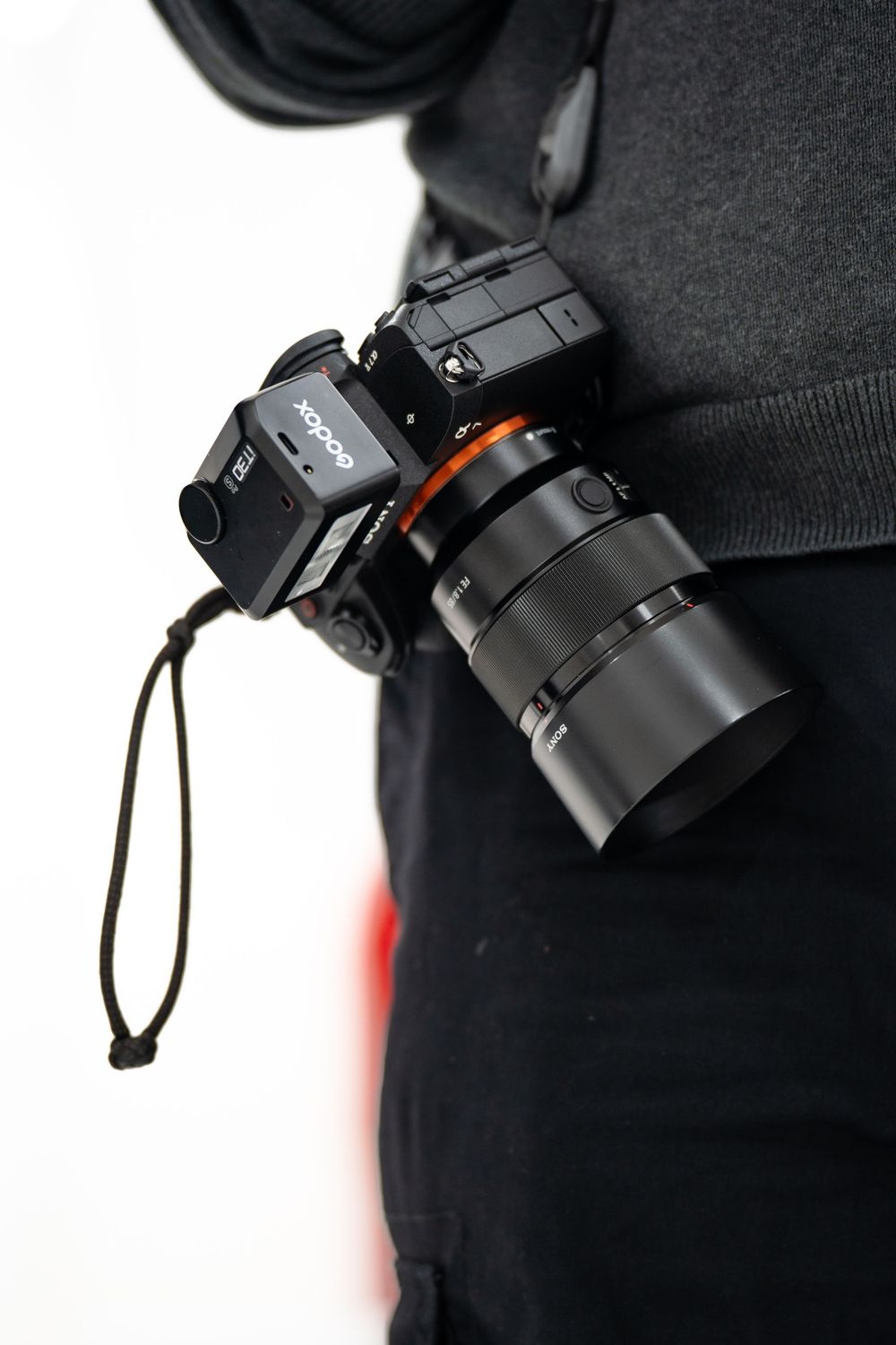 A black Sony mirrorless camera with lens shown in multiple angles against a dark background.