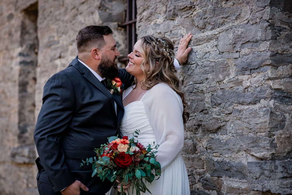 Wedding photography capturing a bride and groom with a historic building in Beaverton, Ontario.
