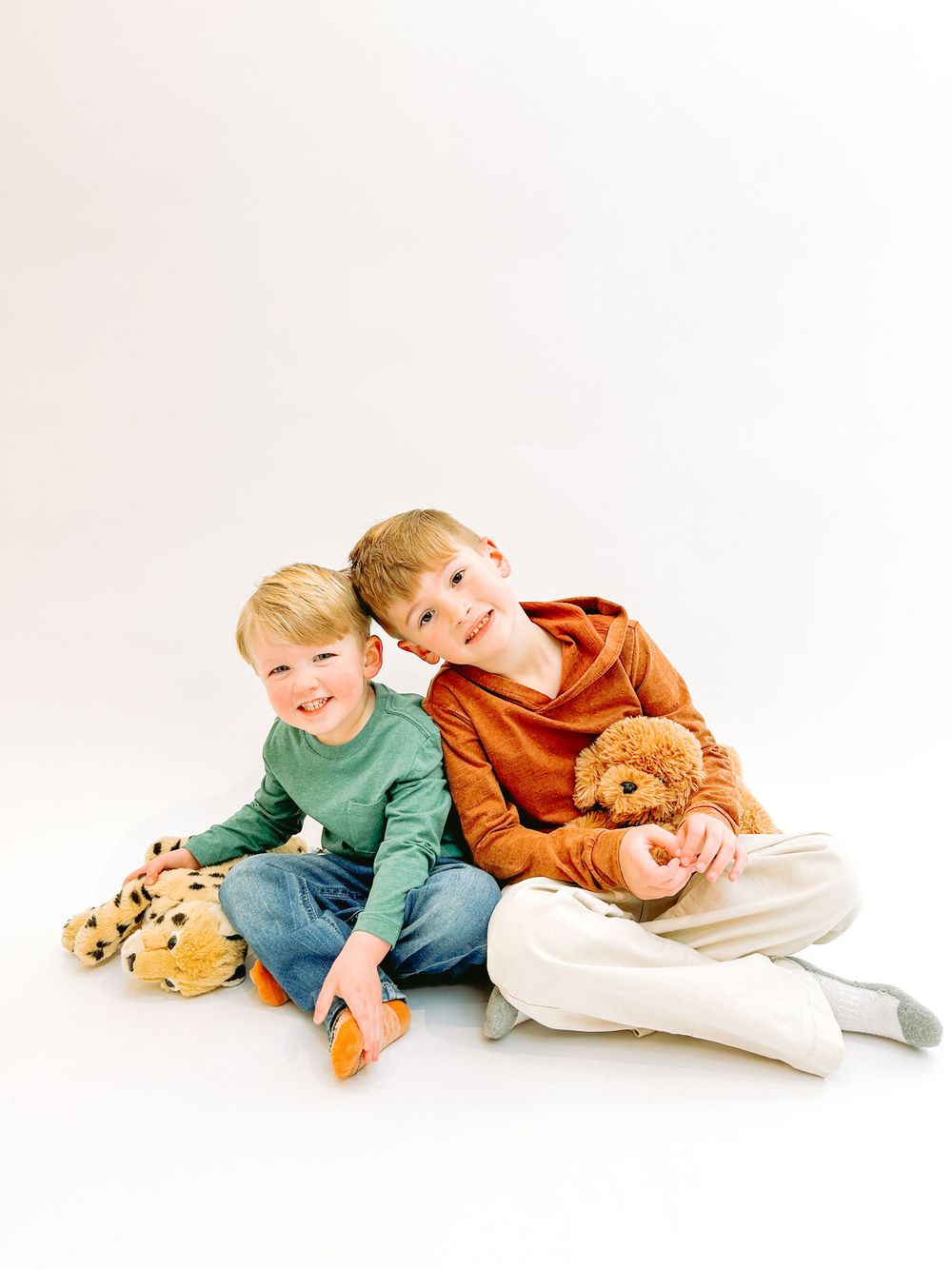 A sequence of playful poses showing a child in casual clothing lying down with a teddy bear against a white background.